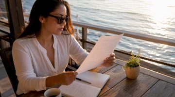 Una mujer analiza cuidadosamente los aspectos legales de varios documentos.