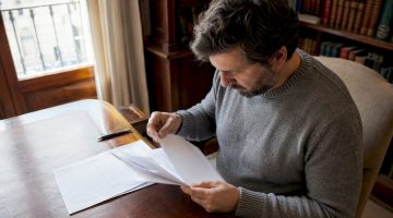 Un hombre revisa cuidadosamente la documentación relacionada con la licencia de un casino.