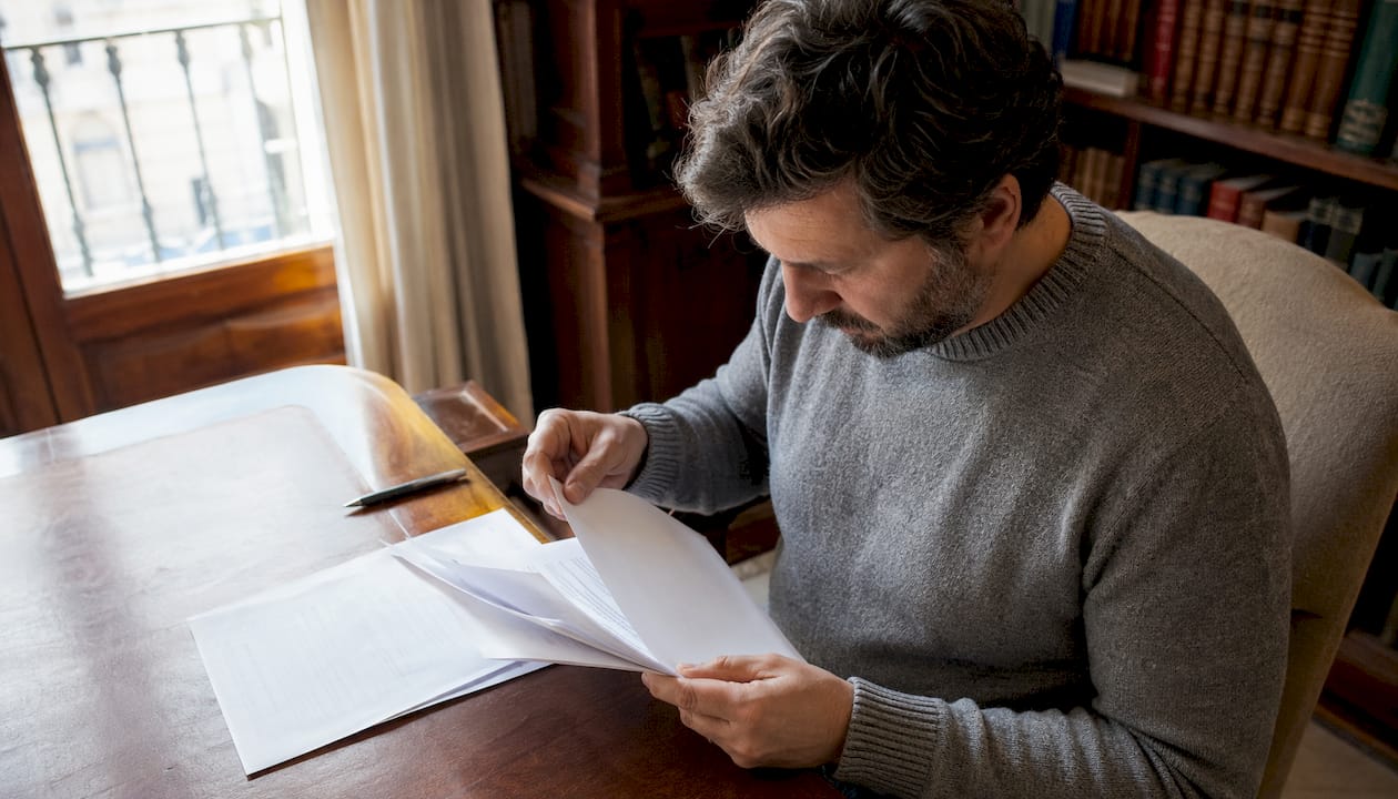 Un hombre revisa cuidadosamente la documentación relacionada con la licencia de un casino.