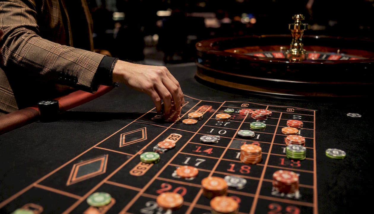 Una mano apostando fichas en una ruleta en directo